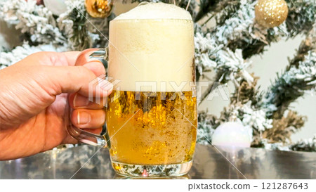 男手拿著生啤酒，背景是聖誕樹 121287643