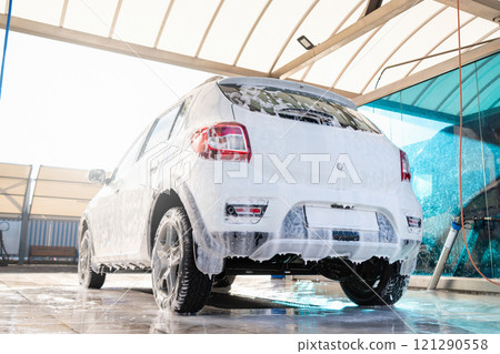 Self service high pressure car wash. Vehicle covered with foam 121290558