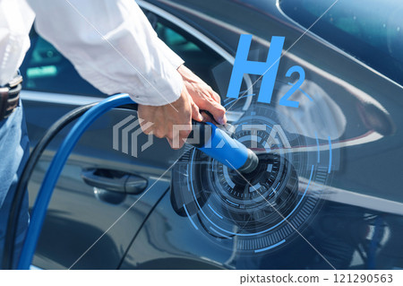 Man holds a hydrogen fueling nozzle on a hydrogen filling station. Refueling car with hydrogen fuel 121290563