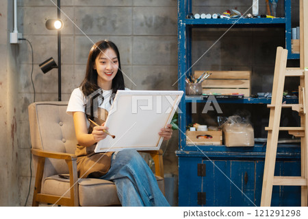 Young female artist painting on canvas in the home studio, fine arts and creativity concept. 121291298