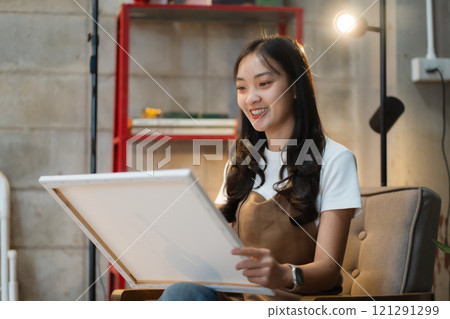 Young female artist painting on canvas in the home studio, fine arts and creativity concept. Young female artist painting on canvas in the home studio, fine arts and creativity concept. 121291299