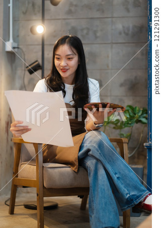 Young female artist painting on canvas in the home studio, fine arts and creativity concept. 121291300