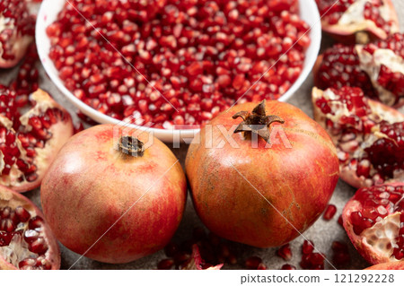 Ripe organic pomegranates and pomegranate seeds close-up 121292228