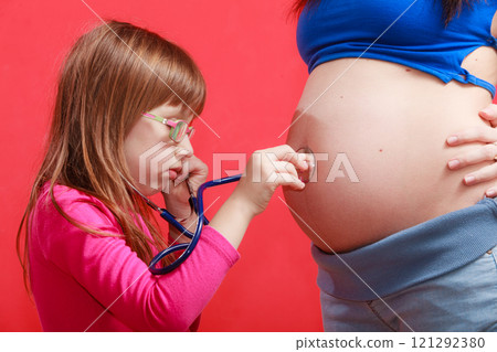 Daughter using stethoscope on pregnant mother Daughter using stethoscope on pregnant mother 121292380