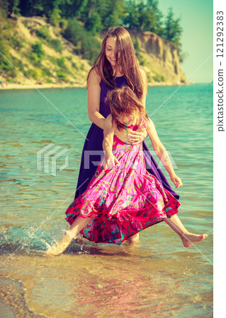 Woman and girl playing in water 121292383