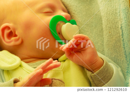 Closeup of little newborn sleeping with teat in mouth Closeup of little newborn sleeping with teat in mouth 121292610