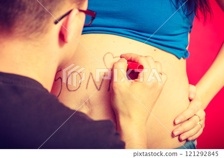 Pregnant woman belly, father drawing on it 121292845
