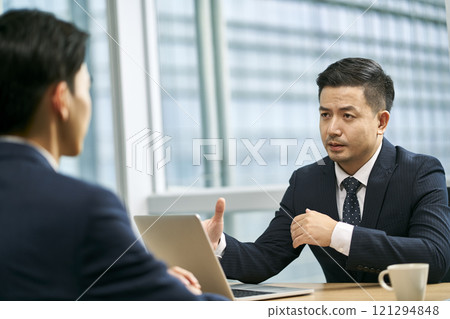 asian corporate executives discussing business in office 121294848