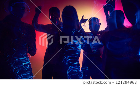 Friends raise glasses high, celebrating holidays in neon lights, dance floor alive with rhythm and joyful energy. Motion blur effect. Friends raise glasses high, celebrating holidays in neon lights, dance floor alive with rhythm and joyful energy. Motion blur effect. 121294968