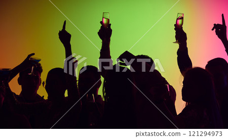 Neon swirls and shimmering drinks highlight vibrant crowd dancing and celebrating life together in electrifying atmosphere. Neon swirls and shimmering drinks highlight vibrant crowd dancing and celebrating life together in electrifying atmosphere. 121294973