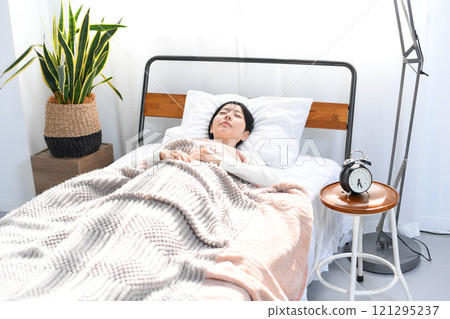 Young Asian woman sleeping comfortably in bed 121295237