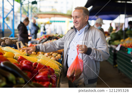 Middle aged man buying vegetables 121295326