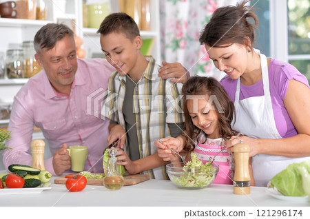 Portrait of beautiful family cooking at kitchen 121296174