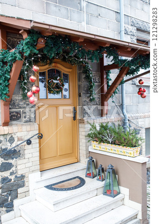 Christmas decorations adorning a house entrance with festive cheer Christmas decorations adorning a house entrance with festive cheer 121298283