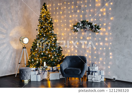 Christmas tree illuminating cozy living room with fairy lights 121298320