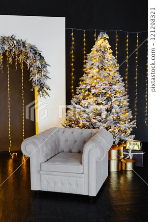 Christmas interior with elegant armchair, decorated tree, and luminous decorations creating festive atmosphere 121298321