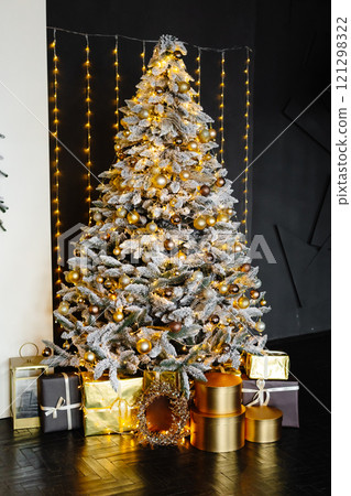 Christmas tree decorated with golden and silver baubles with many gift boxes underneath Christmas tree decorated with golden and silver baubles with many gift boxes underneath 121298322