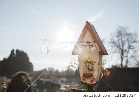 Colorful birdhouse standing in a garden during winter Colorful birdhouse standing in a garden during winter 121298327