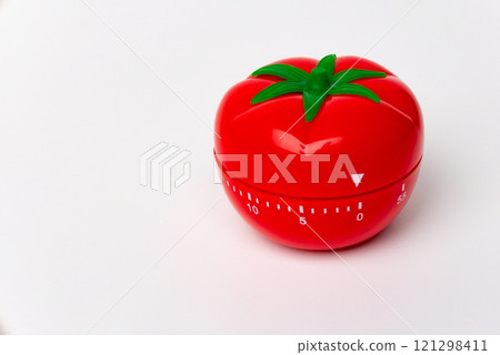 Close up view of mechanical tomato shaped kitchen clock timer for cooking and studying. Used for pomodoro technique for time & productivity management. Isolated on white background, set at 5 minutes. 121298411
