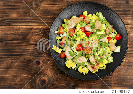Meat salad with vegetables on wooden table. Meat salad with vegetables on wooden table. 121298437