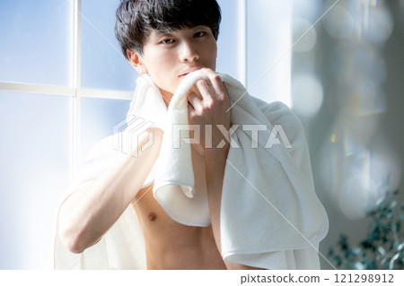 man wiping face with towel 121298912
