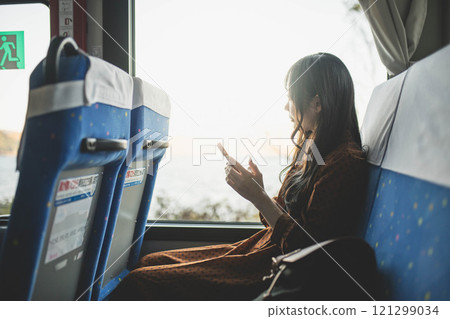 A young woman riding a bus. Photo courtesy of Ugo Kotsu. A young woman riding a bus. Photo courtesy of Ugo Kotsu. 121299034