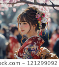 A young woman in a kimono standing in front of a cherry blossom 121299092