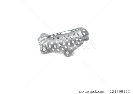 Titanium dental membranes for directed bone regeneration printed on 3D printer isolated on white background. Membrane for lower jaw printed from biocompatible titanium powder. Implants and prostheses Titanium dental membranes for directed bone regeneration printed on 3D printer isolated on white background. Membrane for lower jaw printed from biocompatible titanium powder. Implants and prostheses 121299153