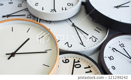 A collection of analog clocks overlapping, featuring minimalist white dials with black hands, creating a clean and organized aesthetic. A collection of analog clocks overlapping, featuring minimalist white dials with black hands, creating a clean and organized aesthetic. 121299242