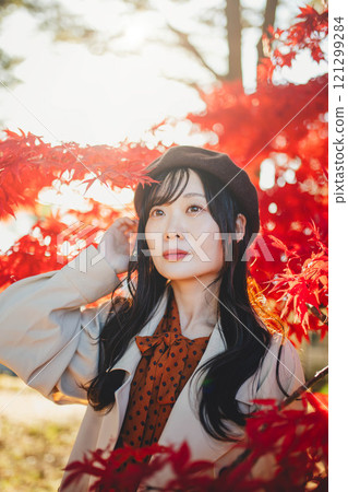 一位戴著貝雷帽的年輕女子尋找秋葉 一位戴著貝雷帽的年輕女子尋找秋葉 121299284