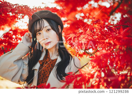 一位戴著貝雷帽的年輕女子尋找秋葉 一位戴著貝雷帽的年輕女子尋找秋葉 121299286