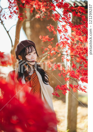 一位戴著貝雷帽的年輕女子尋找秋葉 一位戴著貝雷帽的年輕女子尋找秋葉 121299287