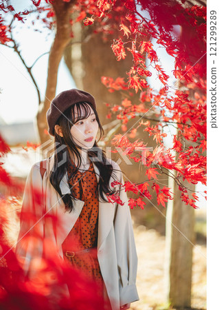 一位戴著貝雷帽的年輕女子尋找秋葉 121299289