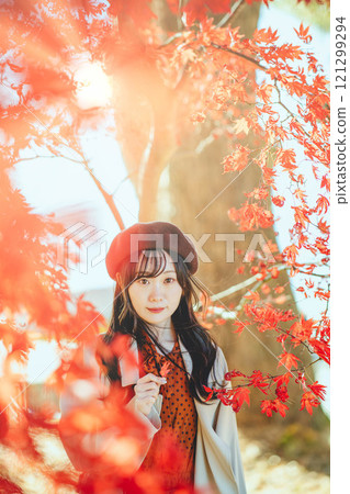 一位戴著貝雷帽的年輕女子尋找秋葉 一位戴著貝雷帽的年輕女子尋找秋葉 121299294