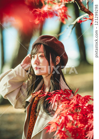 一位戴著貝雷帽的年輕女子尋找秋葉 一位戴著貝雷帽的年輕女子尋找秋葉 121299298