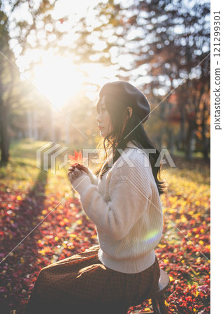 一位戴著貝雷帽的年輕女子尋找秋葉 一位戴著貝雷帽的年輕女子尋找秋葉 121299301