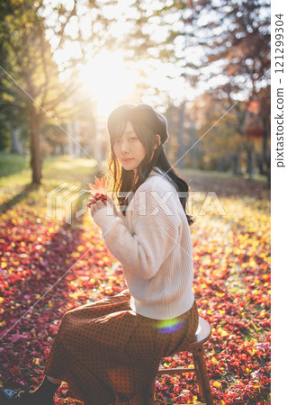 一位戴著貝雷帽的年輕女子尋找秋葉 121299304