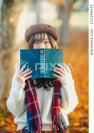 秋季閱讀：一位年輕女子在秋葉公園讀書 121299435