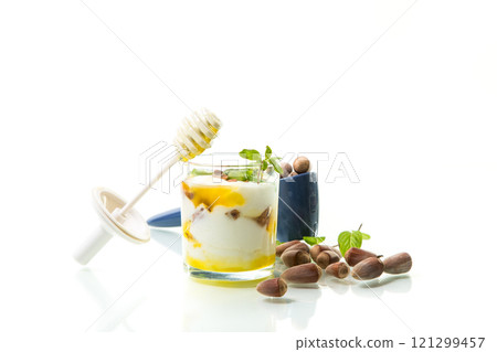 homemade yogurt with kiwi, honey and nuts in a glass, isolated on white background 121299457