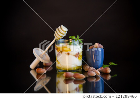 homemade yogurt with kiwi, honey and nuts in a glass, isolated on black background homemade yogurt with kiwi, honey and nuts in a glass, isolated on black background 121299460