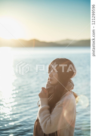 湖和日落,戴著圍巾的年輕女子 湖和日落,戴著圍巾的年輕女子 121299596