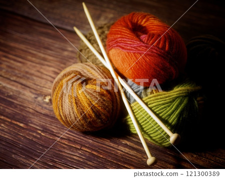Yarn and knitting needles on a wooden table 121300389