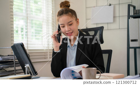 Businesswoman sitting at desk on couch in workplace or at home working on laptop and analyzing data on charts and graphs and writing on papers to make business plan and strategies for company, Businesswoman sitting at desk on couch in workplace or at home working on laptop and analyzing data on charts and graphs and writing on papers to make business plan and strategies for company, 121300712