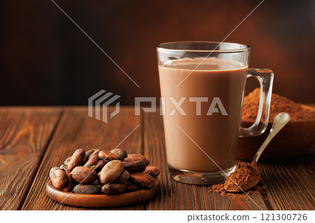 hot chocolate in cup and cacao beans with powder on table hot chocolate in cup and cacao beans with powder on table 121300726