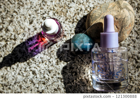 Cuticle oil, facial skin essence, serum in a dropper bottle. Natural decorative cosmetics on stone background flatly. Aesthetics and beauty concept. Cuticle oil, facial skin essence, serum in a dropper bottle. Natural decorative cosmetics on stone background flatly. Aesthetics and beauty concept. 121300888