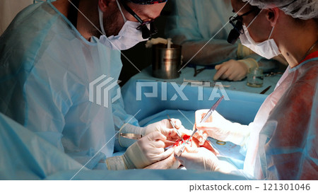 Experienced surgeons conducting high stakes surgery in a sterile operating room with precision and teamwork. Gloved hands wielding scalpels 121301046