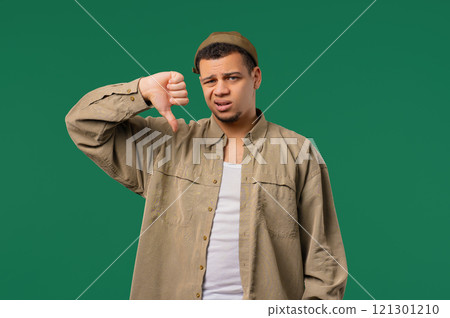 Young multiracial man with sign of dislike. European dude expressing thumbs-down Young multiracial man with sign of dislike. European dude expressing thumbs-down 121301210