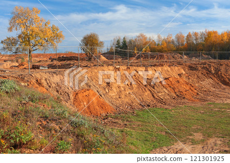 Construction site in fall on sunny day in countryside. Beginning of construction site. Ground and trees. Sand and clay.  121301925