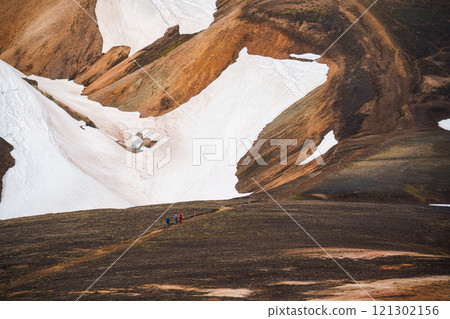 Volcanic mountain with group of hiker hiking on hill in summer at Iceland 121302156