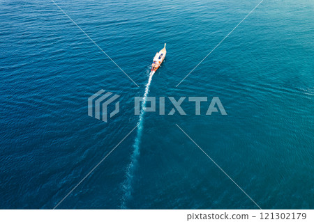 Wooden fishing boat sailing in tropical blue sea during summer on sunny day Wooden fishing boat sailing in tropical blue sea during summer on sunny day 121302179